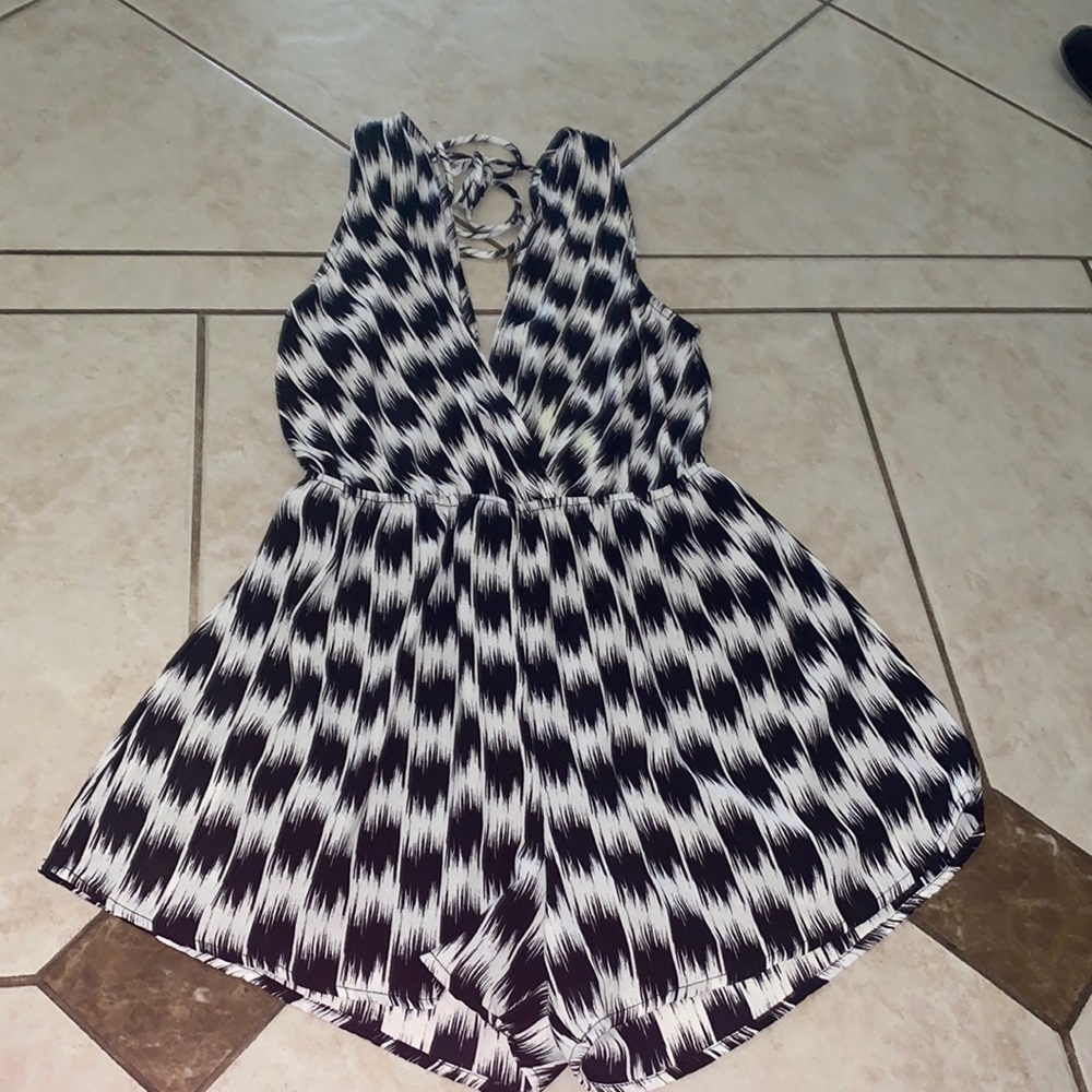 NWT super fun black and white romper with a low cut neckline